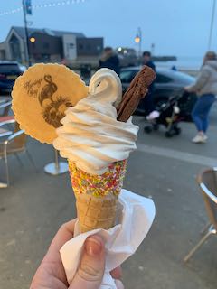 whippy ice cream in a sprinkle cone with a flake and waffle